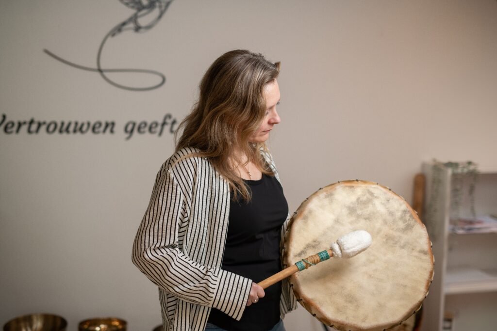 Angela bespeelt een sjamanentrom tijdens een sound healing sessie in Nijmegen